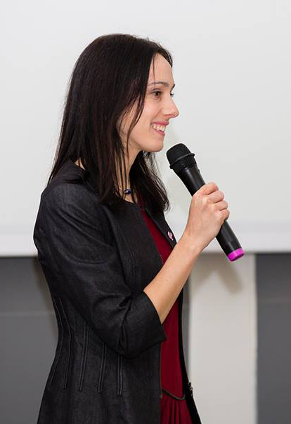 Adriana Sánchez con un micrófono en la mano presentando ARITY ante un tribunal.